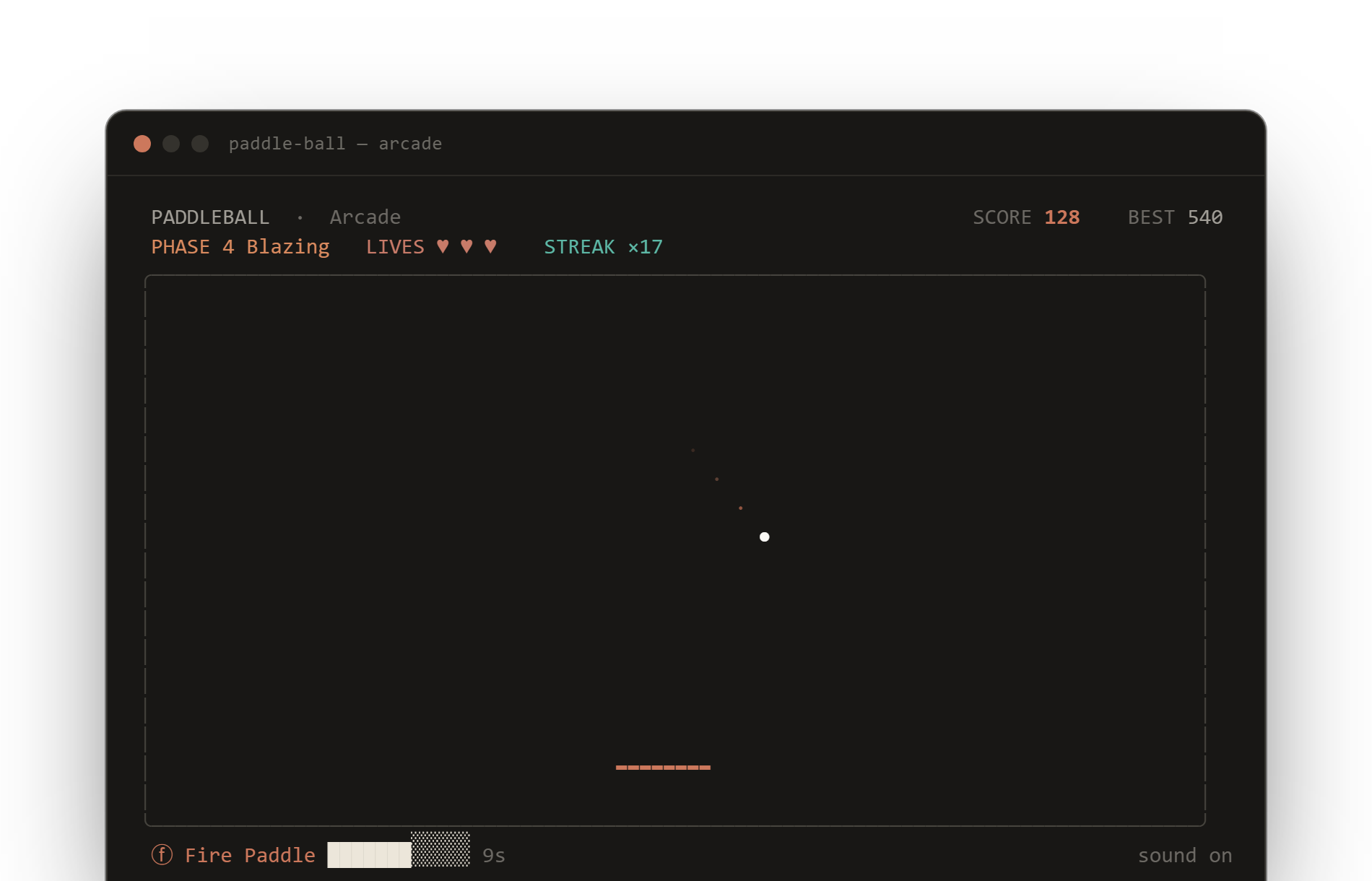 paddle-ball running in a terminal: Arcade mode showing score 128, phase 4 Blazing, three lives, a 17 streak, the ball and its trail, the coral paddle, and an active Fire Paddle power-up.